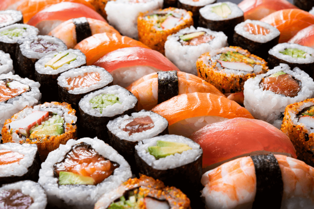 Colorful assortment of sushi and maki rolls featuring nigiri, and specialty rolls, artistically arranged and filling the entire frame