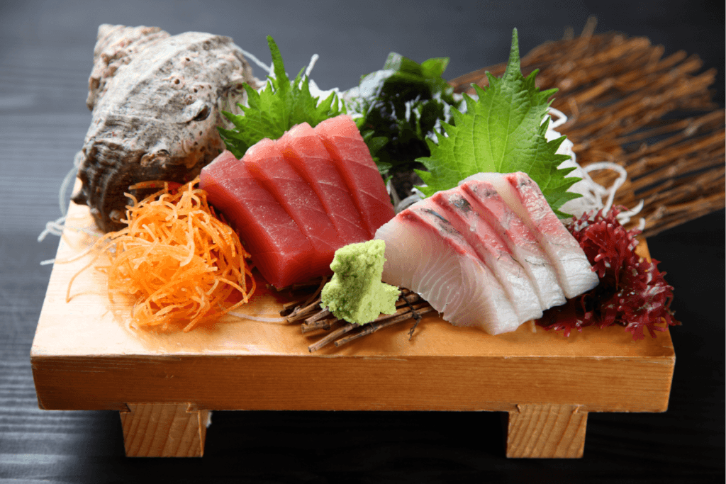 Beautifully arranged sashimi platter featuring fresh hamachi, tuna slices, and turban shell, served as traditional Japanese cuisine"